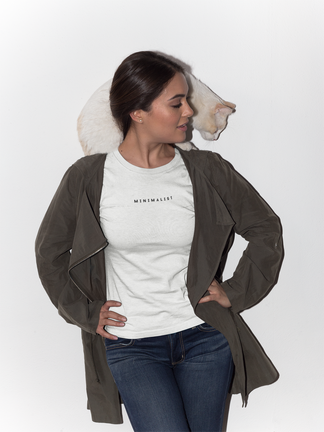 how to dress like a minimalist, women wearing a white t shirt that says minimalist on it, on her shoulder there is a white cat sitting